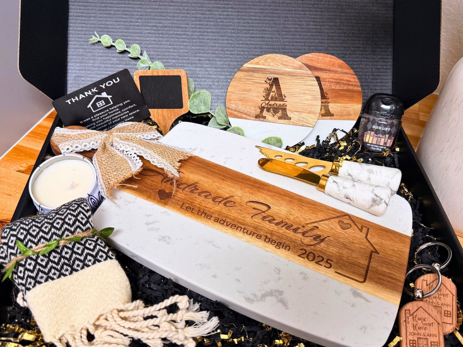 Kintoir personalized client gift box featuring an engraved cutting board, marble coasters, and cheese knives in black