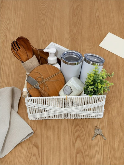 Kintoir Cozy Home Essentials gift basket featuring wooden kitchen tools, white tumblers, a candle, and a faux plant.