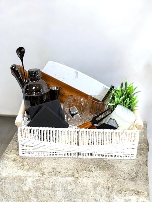 Kintoir Entertainer Essentials cocktail gift basket with bar tools, glasses, cutting board, and faux plant.