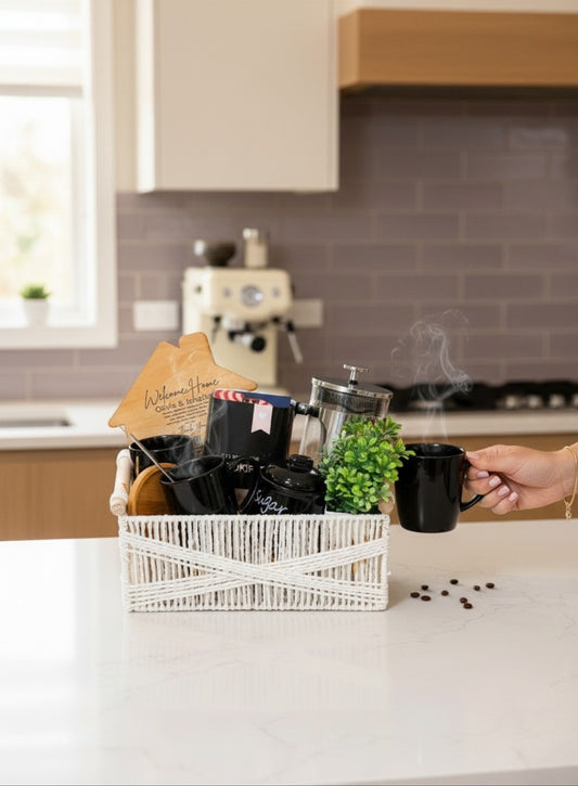 Kintoir luxury coffee gift basket featuring a silver French press, black mugs, sugar jar, and wooden house in a white bin.