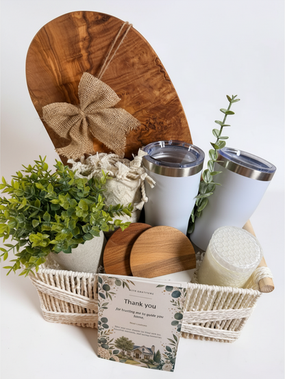 Ready-to-gift new homeowner basket with olive wood board, tumblers, wood coasters, candle and faux plant