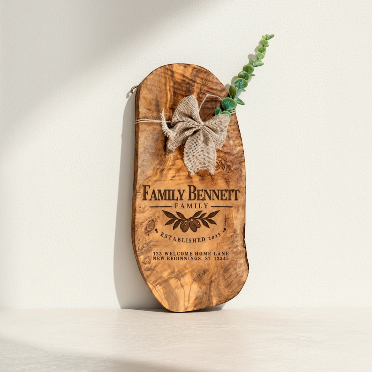 Personalized olive wood serving board engraved with family name and decorative design for a Realtor closing gift