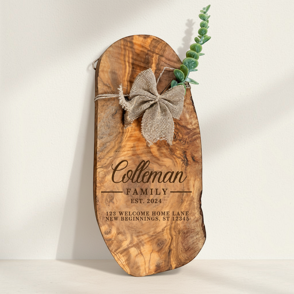 Personalized olive wood serving board with family name engraving, burlap bow and greenery