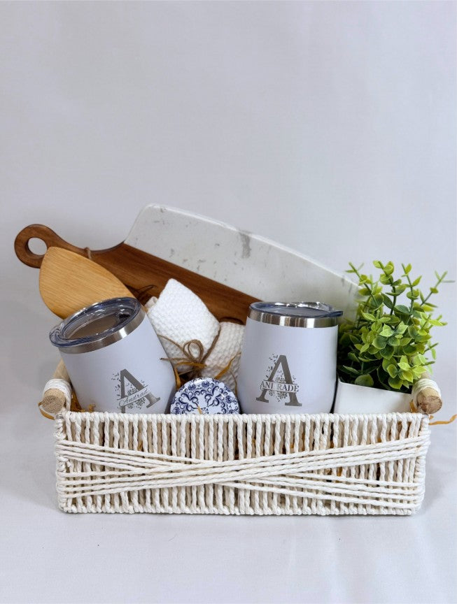 Personalized closing gift basket with engraved cutting board, wine tumblers, candle and greenery