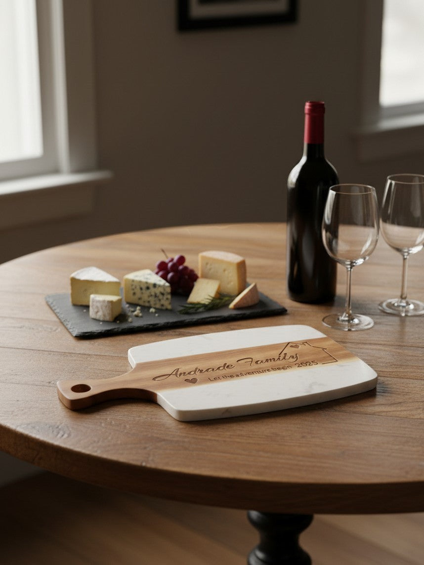 Kintoir personalized wooden and marble cutting board with laser-engraved family name on a round wooden table.
