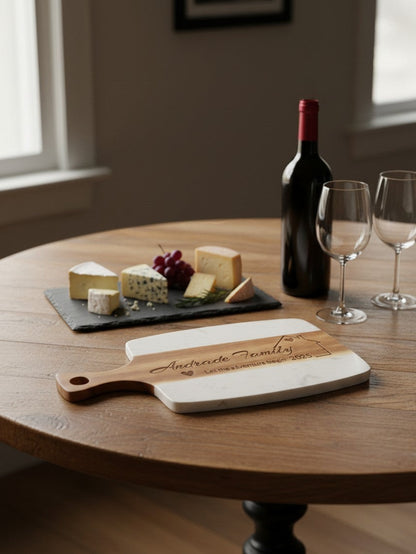 Kintoir personalized wooden and marble cutting board with laser-engraved family name on a round wooden table.