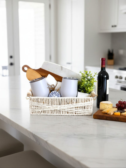 Modern Home Celebration new home gift basket with wine tumblers, cutting board, and home accents on a kitchen island.